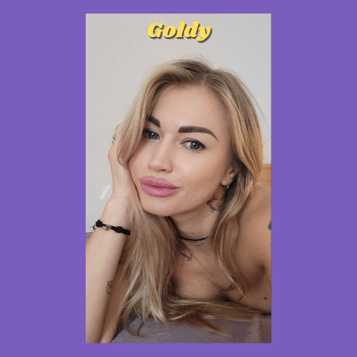 IndieCamModels Girl Next Door Cam Model Goldy IndieCamFans smiling sexily with pink lipstick on and her blonde hair laying on her shoulders.